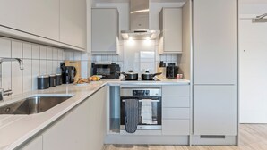 A modern kitchen with a built-in oven, microwave, and coffee maker.