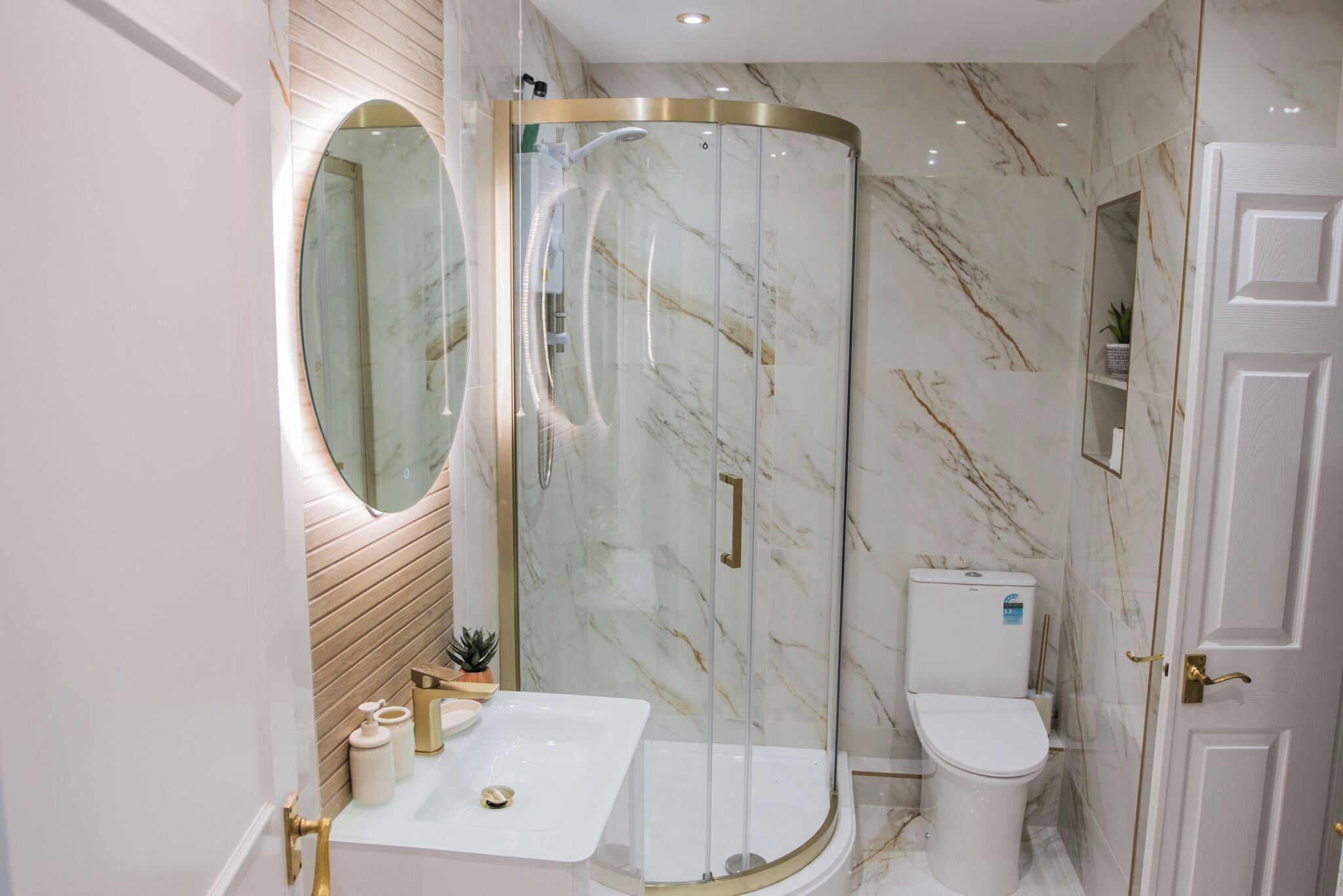 Un baño moderno con ducha de vidrio, lavamanos y retrete.