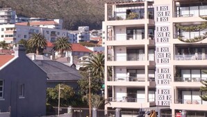 A modern building with multiple balconies and a view of a mountain. - Cozy Corner Apartment (Cape Town)