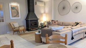 A cozy living room with a fireplace, a sofa, a chair, and a dining table. - 8 Bed Villa with Private Pool & Terrace (Montouliers)