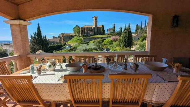 A table set for four with a view of a historic building and surrounding greenery. - 8 Bed Villa with Private Pool & Terrace (Montouliers)