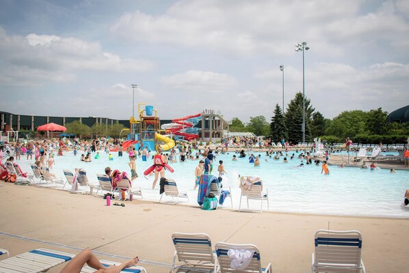 Une piscine publique dotée de plusieurs toboggans et d’une zone couverte pour les spectateurs.