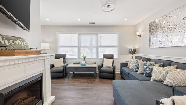 Un salon avec une cheminée, un canapé, une table basse et un téléviseur fixé au mur.