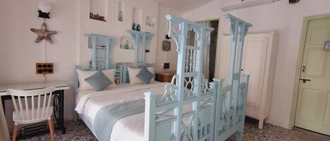 Un dormitorio con cama con dosel, un escritorio y una silla.