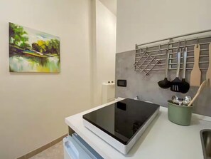 Køleskab, kogeplade, køkkentøj/tallerkener/redskaber, spisebord