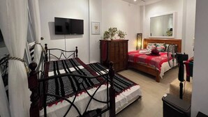 Un dormitorio con dos camas, televisión, espejo y ventilador de techo.