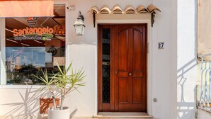 Fachada con puerta de madera y planta en maceta.