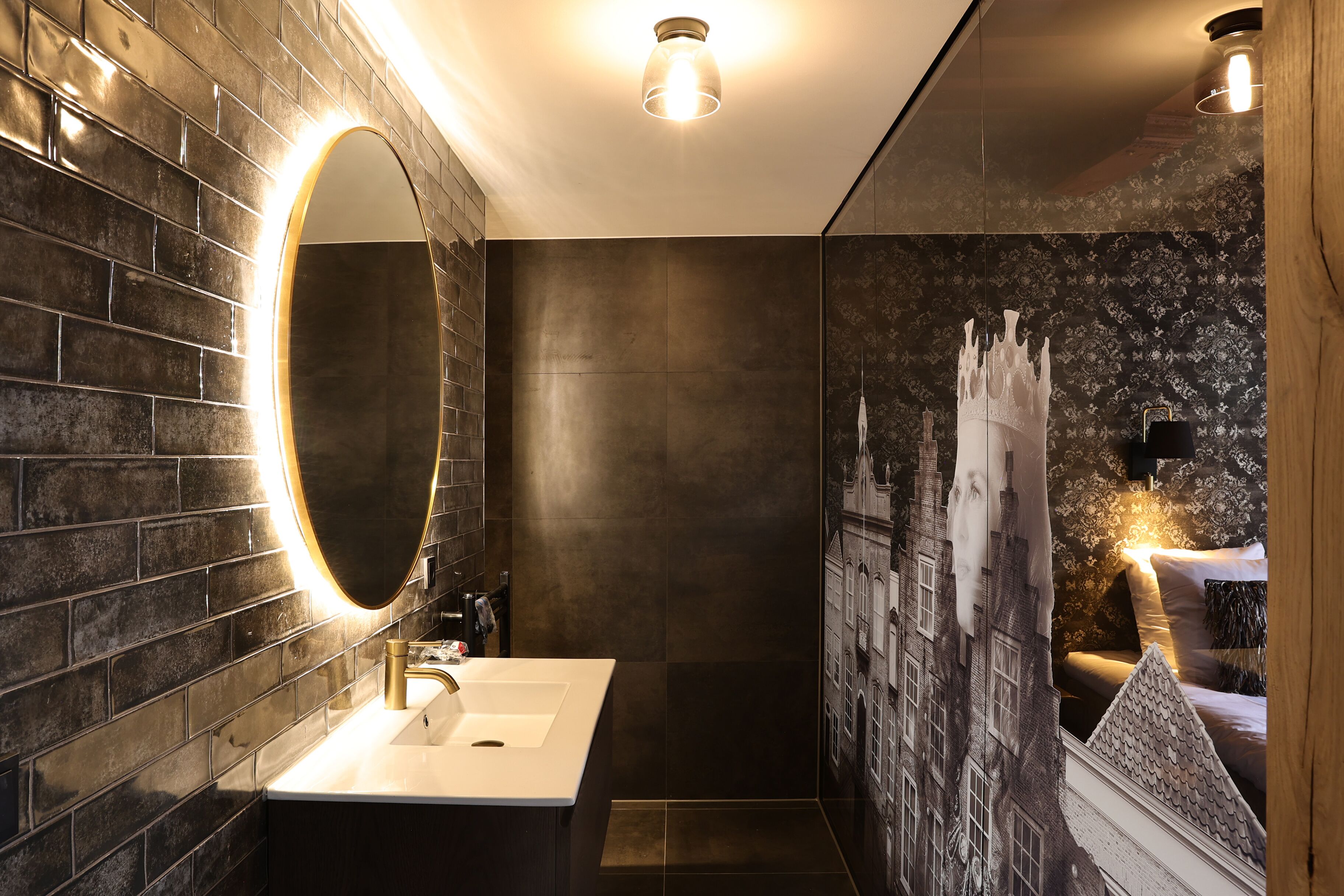 A modern bathroom with a large mirror, a sink, and a shower area.