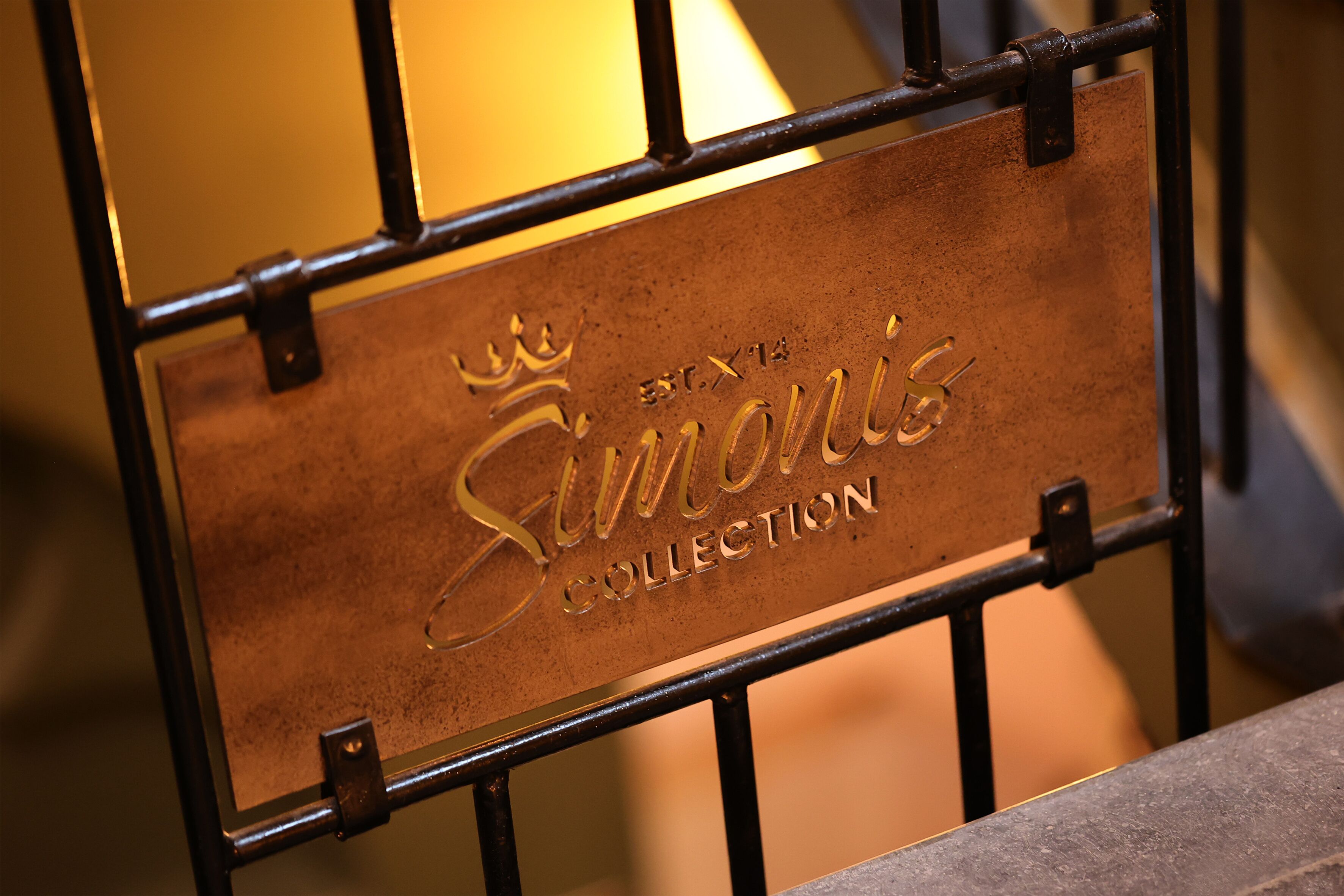 A metal plaque with the inscription "Simonis Collection" mounted on a metal structure.