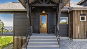 Un bâtiment en bois, doté d’une façade sombre, d’une porte en bois et d’un escalier menant à l’entrée.
