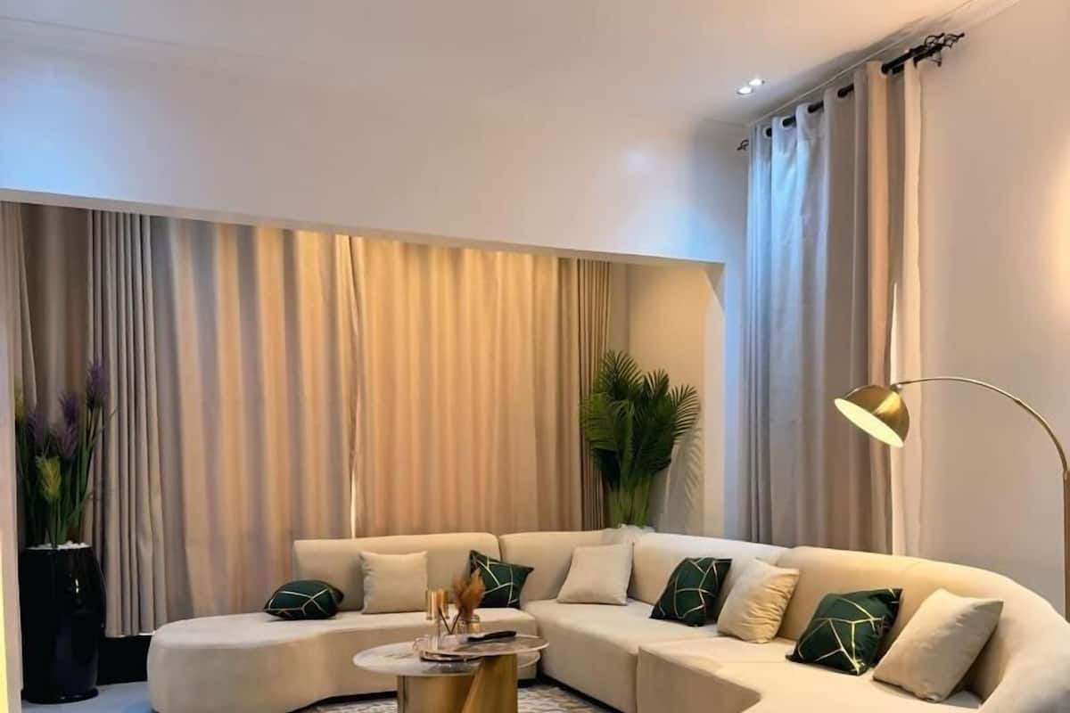 A modern living room with a beige sectional sofa, a round coffee table, and a floor lamp.