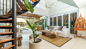 Un salon moderne avec un escalier, une piscine et de grandes fenêtres.