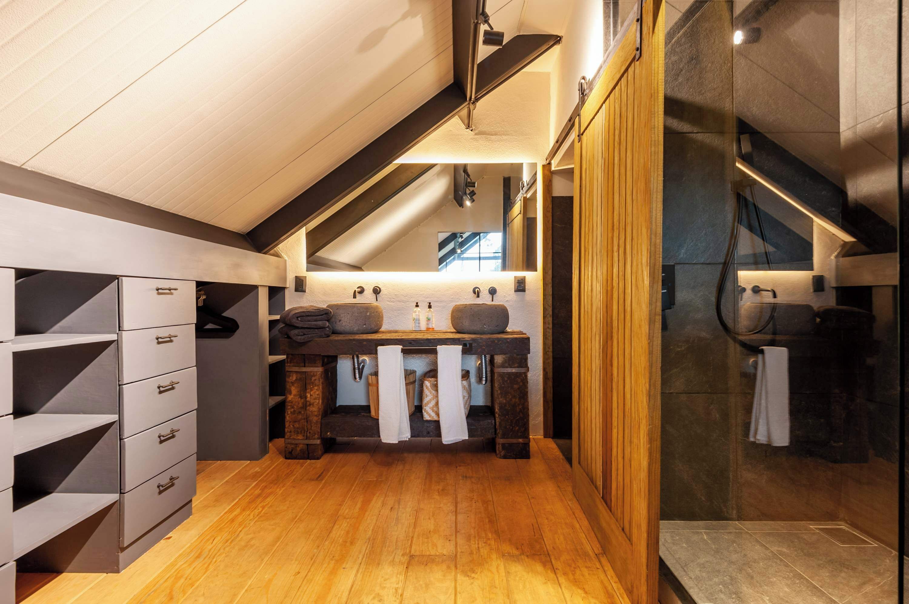 Une salle de bain moderne avec un meuble-lavabo en bois, un grand miroir et un espace douche.
