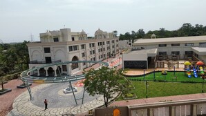 A hotel with a central courtyard, a playground, and a fountain.