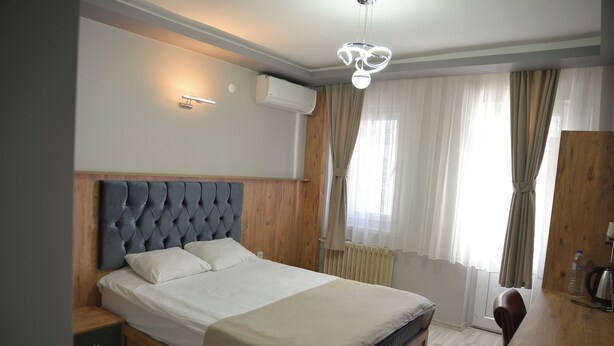 A bedroom with a large bed, wooden headboard, bedside tables, and a built-in wardrobe.