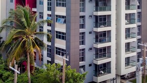 A multi-story residential building with balconies, large windows, and a modern architectural design.
