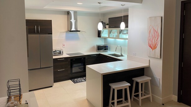 A modern kitchen with a central island, stainless steel appliances, and pendant lighting.