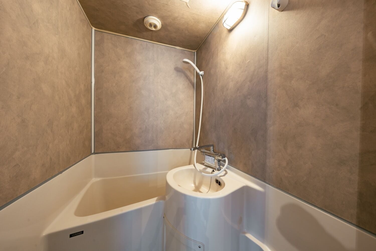 A modern shower area with a handheld showerhead and a control panel.