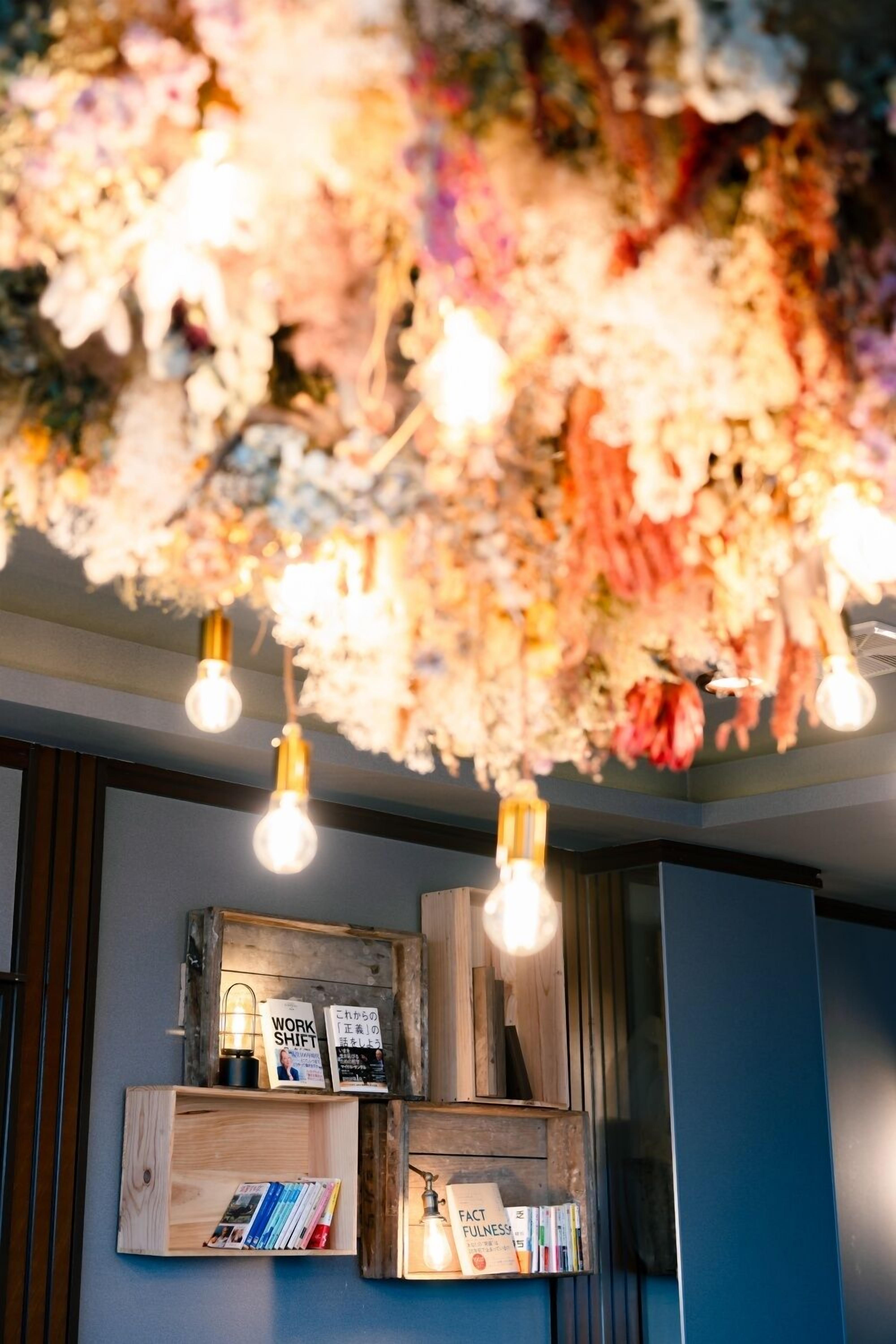 A ceiling with a floral arrangement and hanging light bulbs.