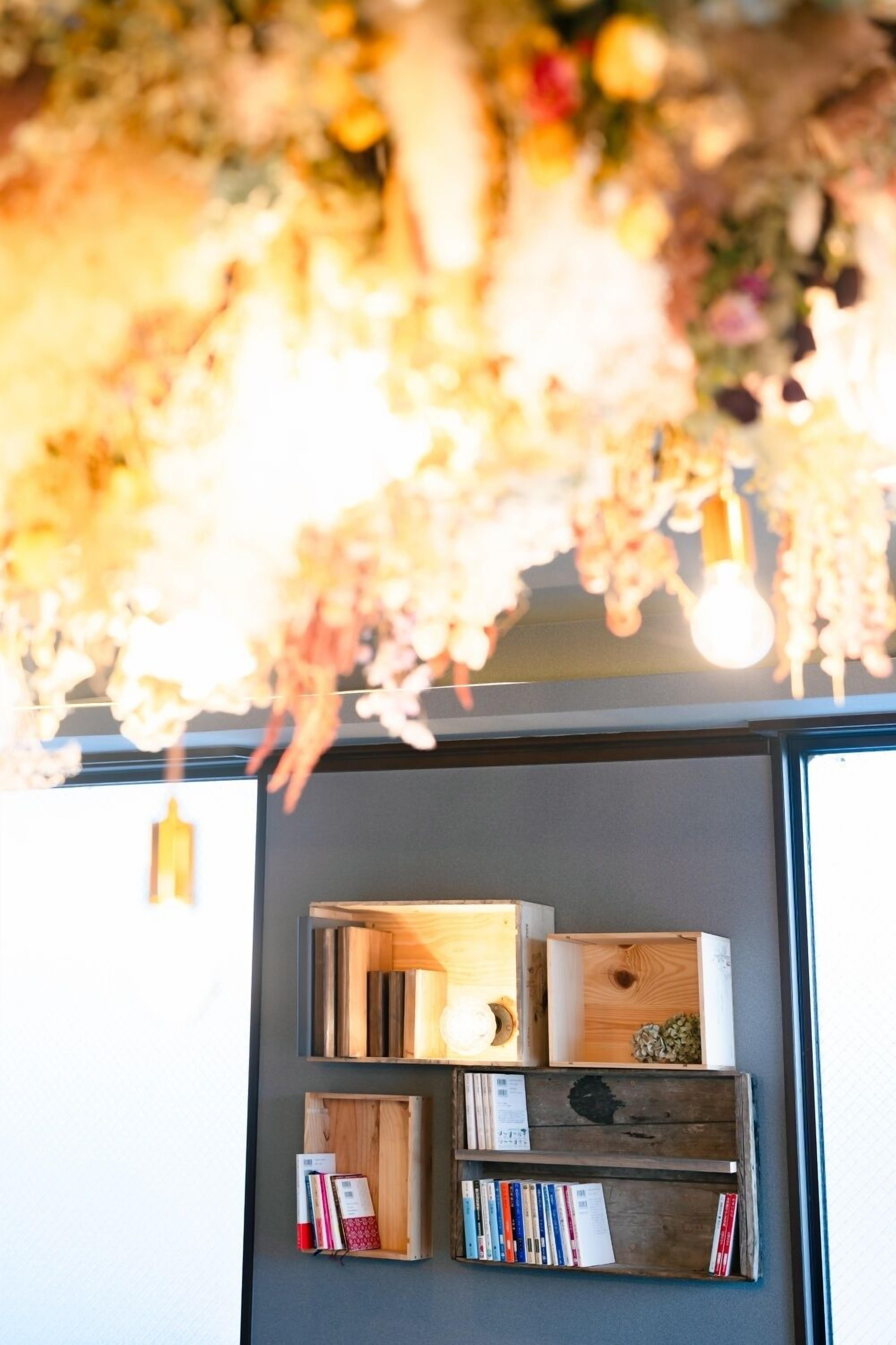 A bookshelf with books and decorative items, a light bulb, and a wooden box with a plant.