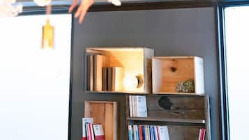 A bookshelf with books and decorative items, a light bulb, and a wooden box with a plant.