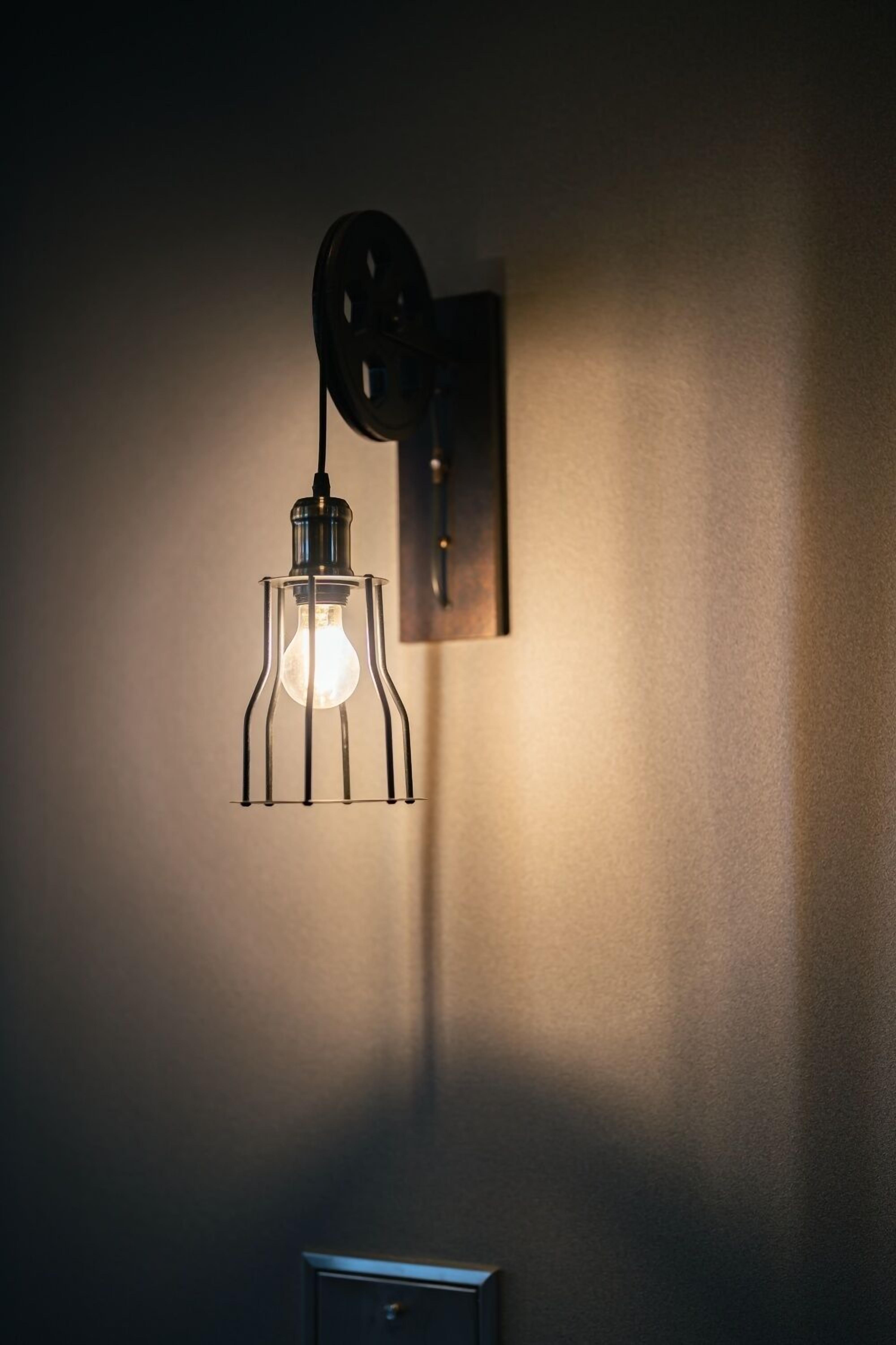 A wall-mounted light fixture with a visible switch and a pull chain.