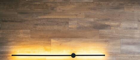Una pared con diseño de panel de madera y un letrero de neón que dice "The Book Lounge Total KANI".
