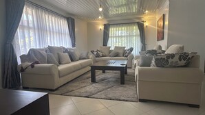 Un salon avec un canapé de couleur beige, une table basse et un tapis.