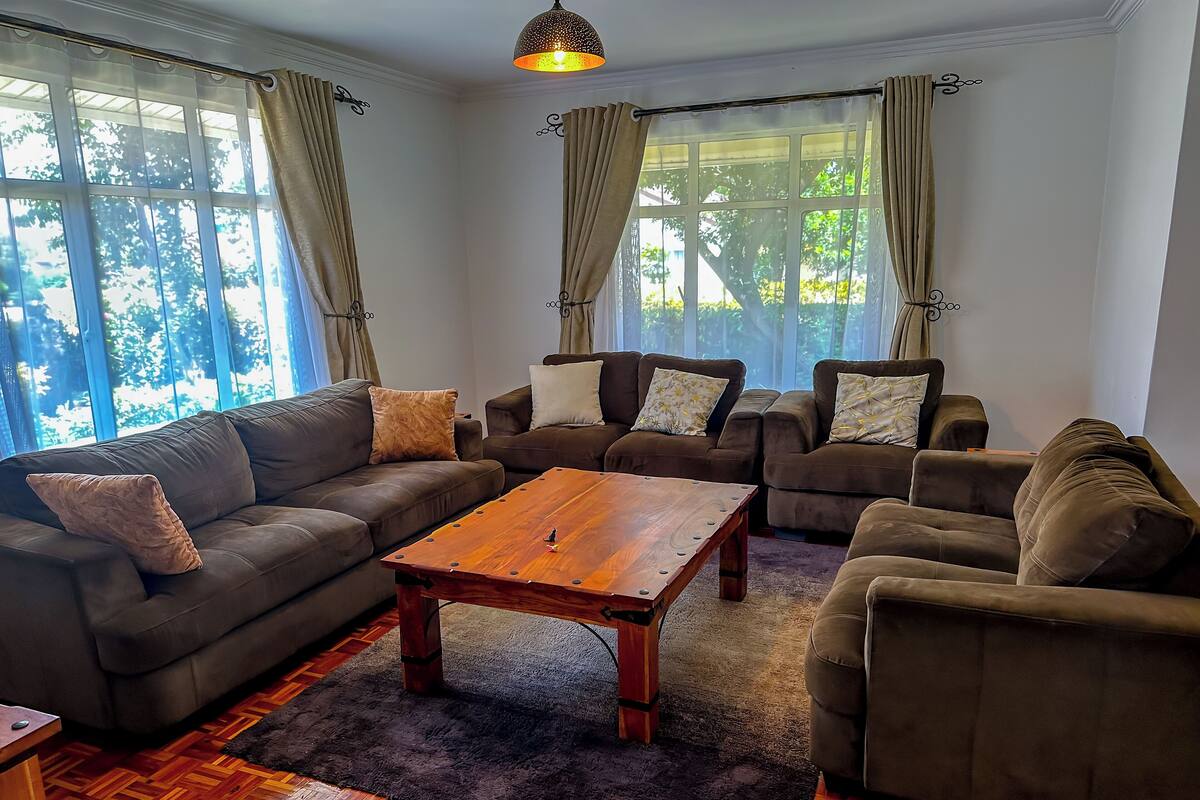 Een woonkamer met een houten salontafel, twee banken en een vloerkleed.
