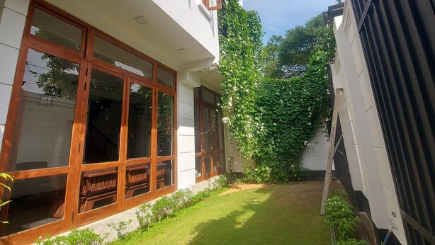 A white building with large windows and a small garden area.