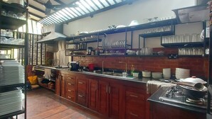 Una cocina con armarios de madera, una estufa a gas y diferentes utensilios de cocina.