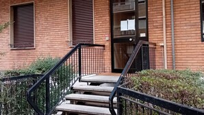 Un bâtiment en briques avec un escalier menant à une porte portant le numéro 5.