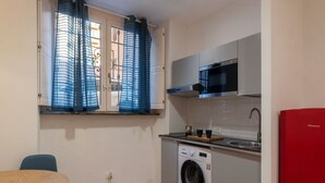 Cocina compacta con lavadora, microondas y lavaplatos.