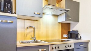 A compact kitchen with a sink, stove, oven, and a coffee maker.