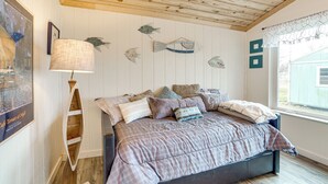 A bedroom with a bed, a wooden ceiling, a window with a view, and wall decorations including fish and a lamp. - Crappie Fishing On Site! Lake Tawakoni Escape (East Tawakoni)