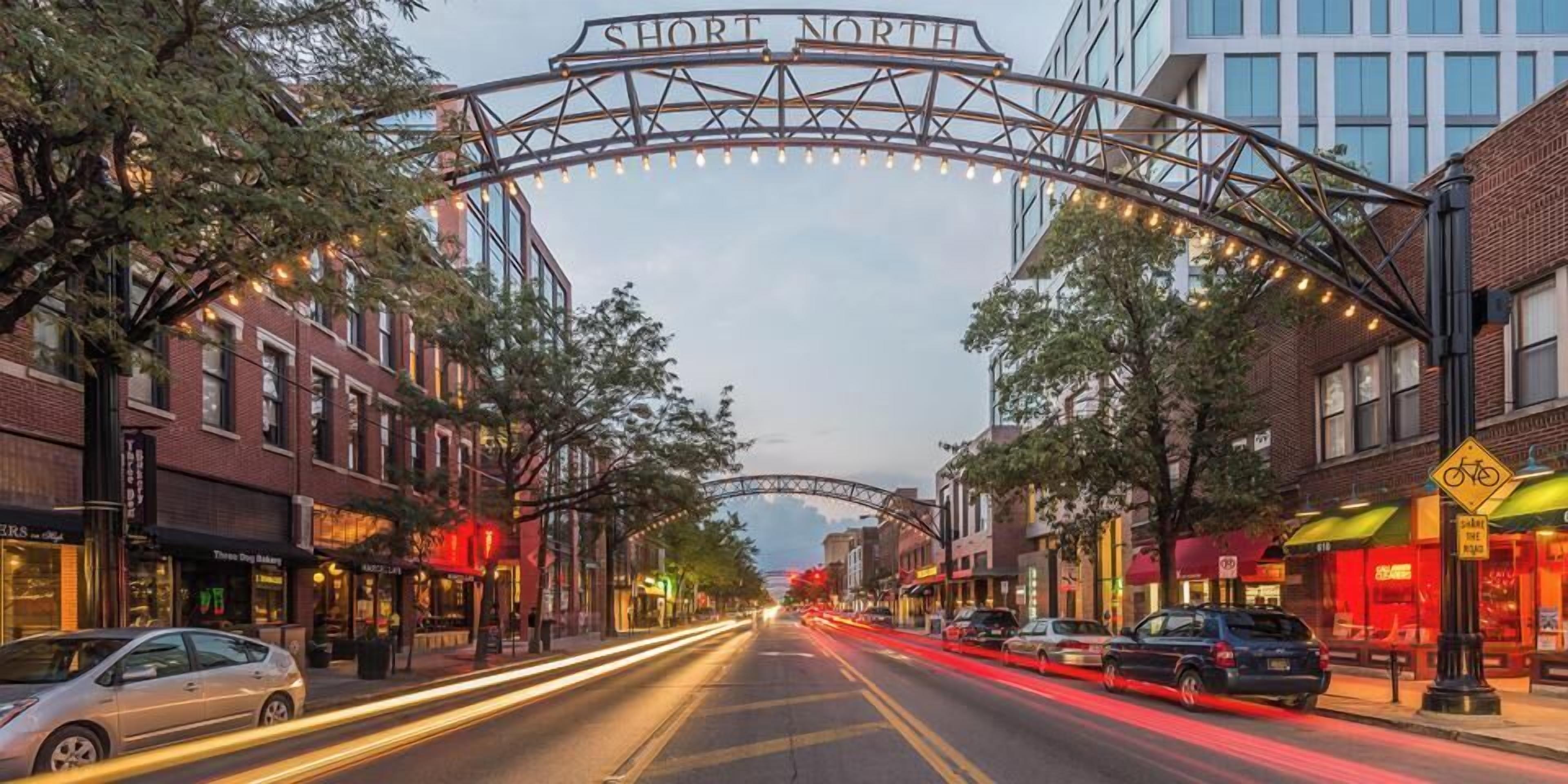 A street with a sign reading 'SHORT NORTH' and a pedestrian bridge overhead.