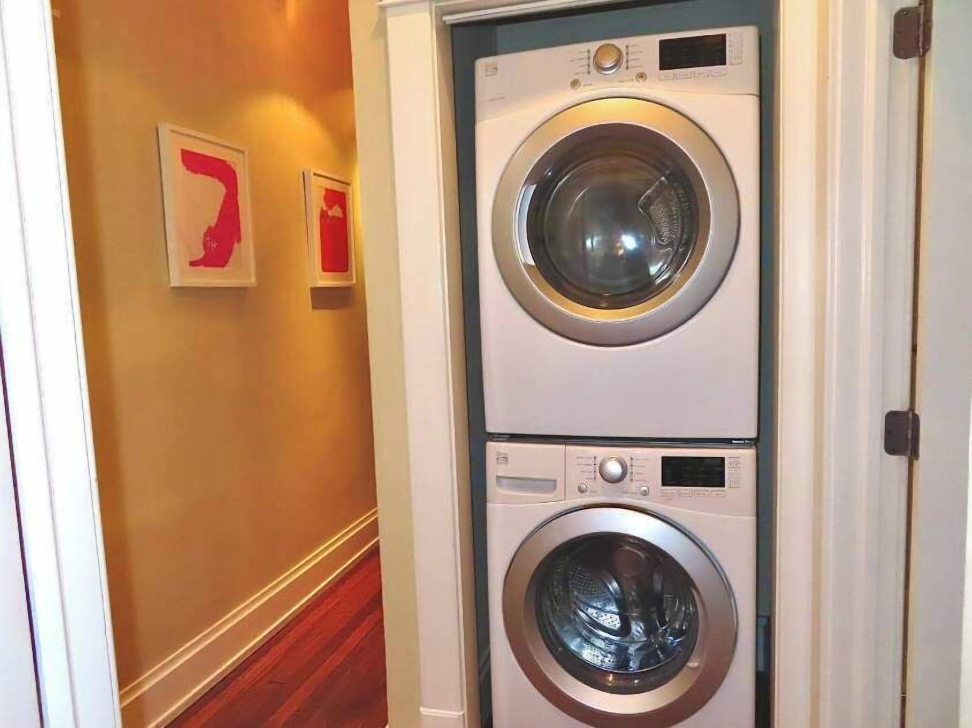 Una sala de bugaderia amb dues rentadores apilades.