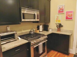 Une cuisine équipée d’un four à micro-ondes, d’une cuisinière, d’un four et d’un grille-pain.