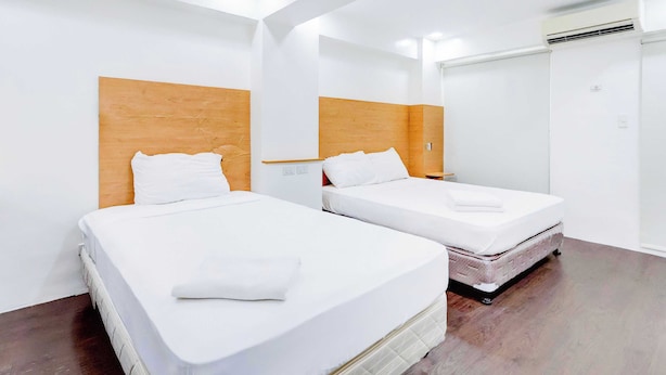 A hotel room with two beds, wooden headboards, white bedding, and a wardrobe. - Townhouse Oak BRBlock Boutique and Residences, Kalayaan Avenue, Near Ayala Mall, Poblacion, Makati, Manila (Makati)