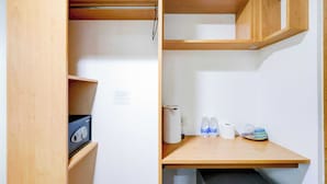 A compact room with a wooden cabinet, a small table with toiletries, and a trash bin. - Townhouse Oak BRBlock Boutique and Residences, Kalayaan Avenue, Near Ayala Mall, Poblacion, Makati, Manila (Makati)