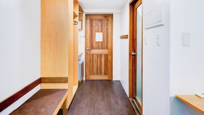 A narrow hallway with wooden flooring, a wooden door, and a small wooden bench. - Townhouse Oak BRBlock Boutique and Residences, Kalayaan Avenue, Near Ayala Mall, Poblacion, Makati, Manila (Makati)