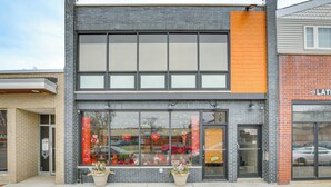 A modern building with large windows and a brick facade. - Steps to Shops & Eats: Apt in Portage Park! (Chicago)