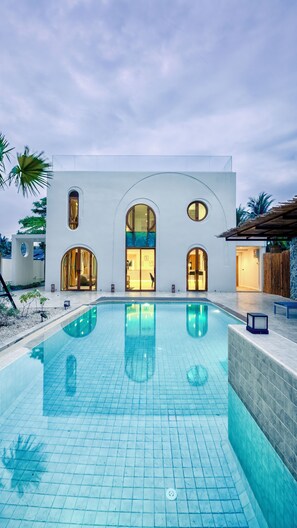 Een buitenzwembad en ligstoelen