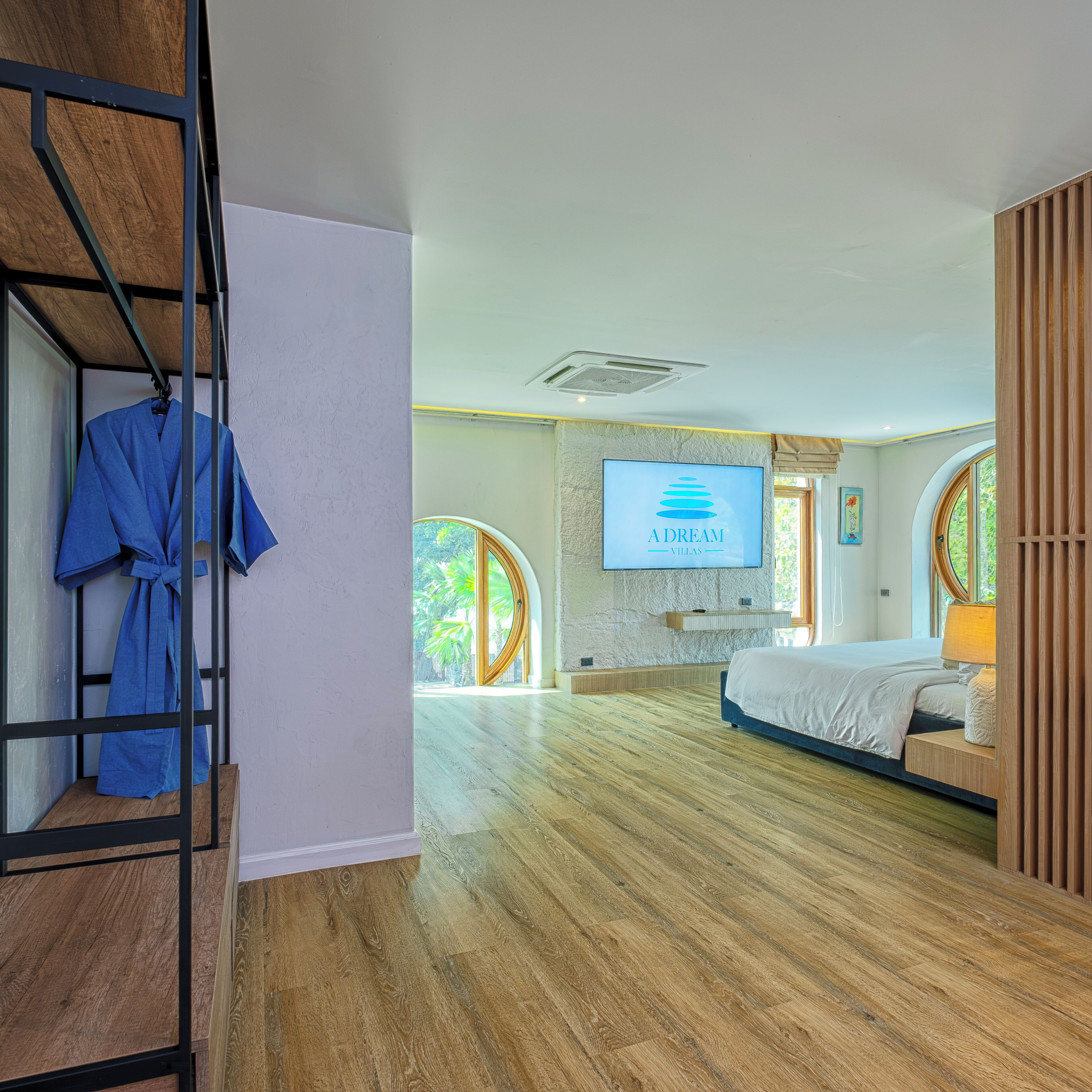 Ein geräumiges Schlafzimmer mit einem Bett, einem an der Wand montierten Fernseher und Holzboden.