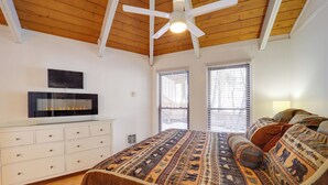 A bedroom with a wooden ceiling, a bed with patterned bedding, a TV on a white dresser, and two windows with blinds. - < 1 Mi to Beech Mtn! All-Season Outdoor Retreat (Beech Mountain)