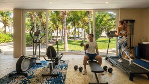 A gym with exercise equipment, a treadmill, and a bench.