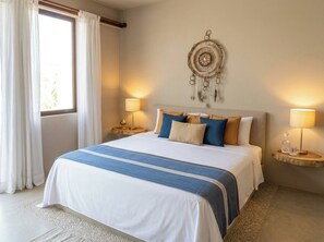 Une chambre d’hôtel avec un grand lit, deux tables de chevet avec des lampes, un élément décoratif mural et une fenêtre avec des rideaux.