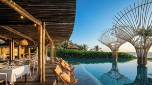 A resort with a pool area, dining setup, and a covered seating area. - Amazing Nicole 1 Ocean Views (Troncones)