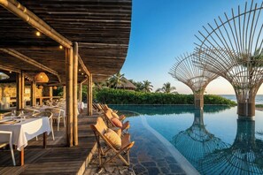 Un resort con area piscina, sala da pranzo e zona relax coperta.