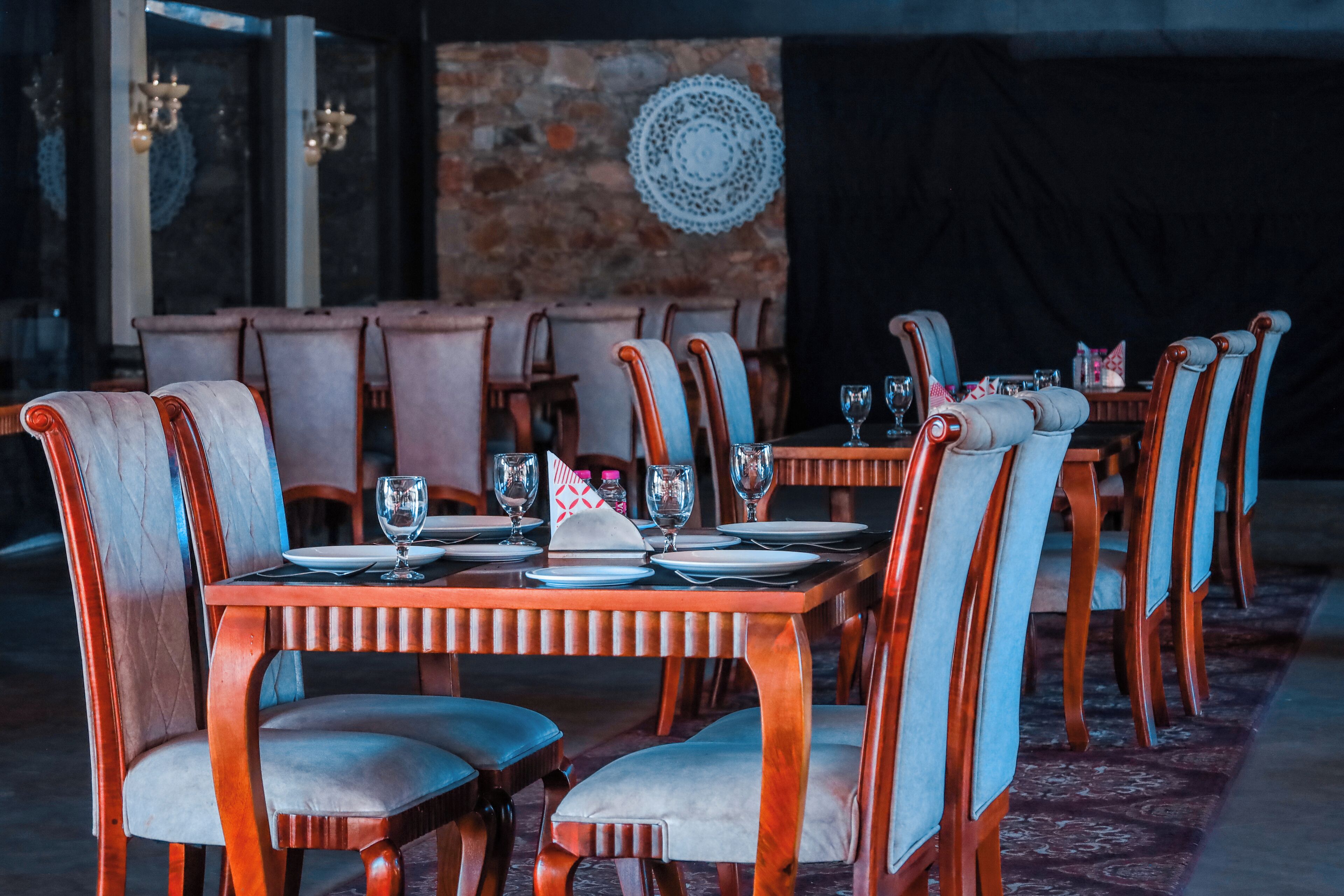 A dining area with wooden tables and chairs, arranged for service.